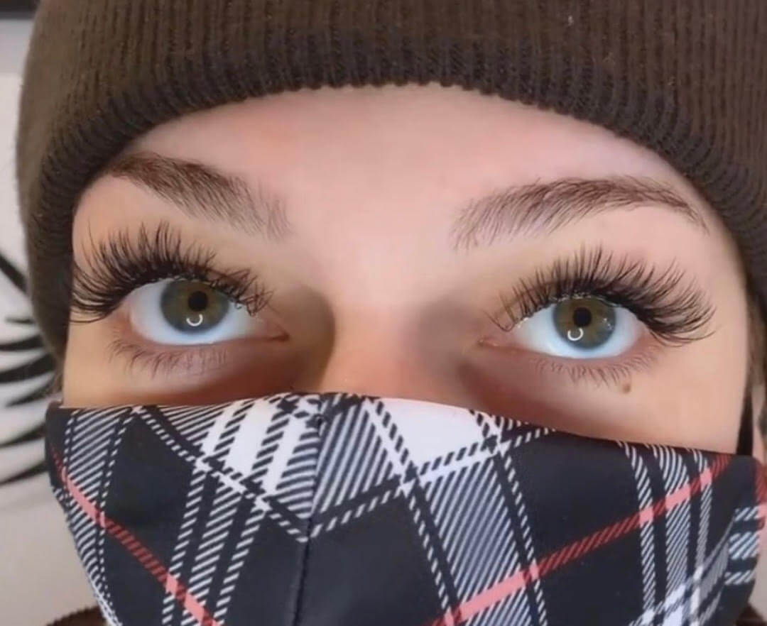 woman with extended lashes wearing a mask